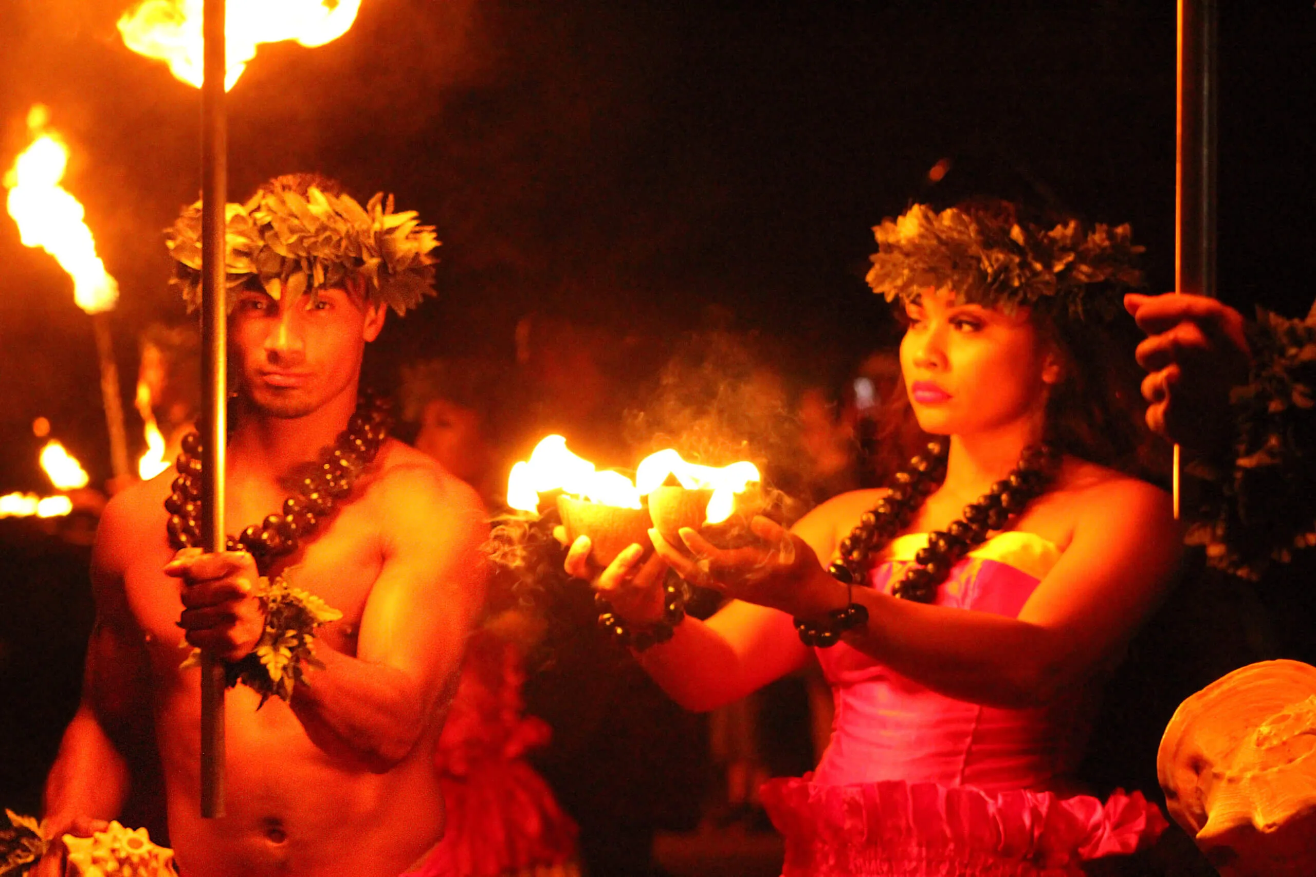 炎のトーチを掲げるダンサーのアップ(ファイアーナイフ)