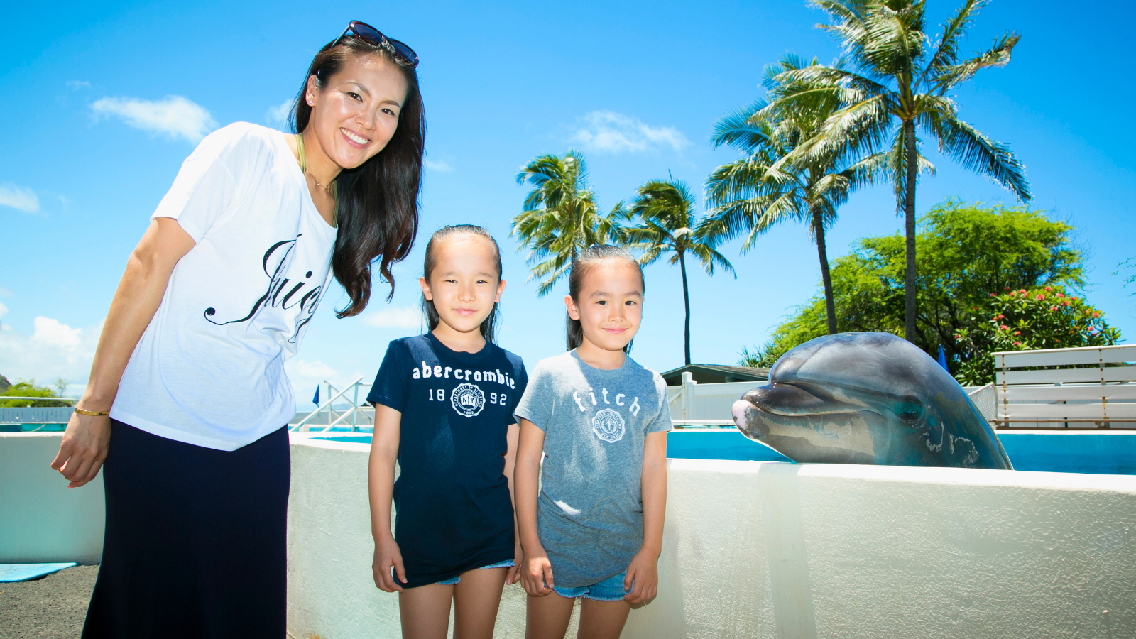 イルカと一緒に記念撮影するファミリー